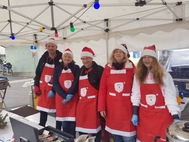 Helferinnen und Helfer am Grillstand mit Samichlaus-Schürzen